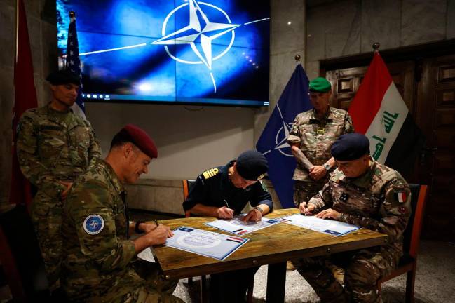 Outgoing Dutch NATO Iraq mission commander Lieutenant General Lucas Schreurs (L), his successor, French Major General Christophe Hintzy (R), and NATO’s Deputy Supreme Allied Commander for Europe, Admiral Sir Keith Edward Blount, take part in a handing over of command ceremony at Union III Camp in the Green Zone of the Iraqi capital Baghdad on May 22. A French major general took command of NATO’s mission in Iraq on May 22, assuming responsibility for efforts to support the country’s fight against jihadists and strengthen its armed forces. - AHMAD AL-RUBAYE / AFP
