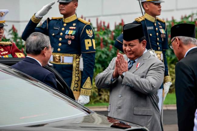 Indonesia’s President Prabowo Subianto (R) greets Chinese Premier Li Qiang upon his arrival before a welcoming ceremony at the Presidential Palace in Jakarta on May 25, 2025. - YASUYOSHI CHIBA / AFP