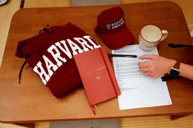 Yu-Hsuan Lin, 27, lays out a Harvard hat, mug, hoodie and her admission letter to Harvard University on a table in Taipei, Taiwan May 24, 2025. - REUTERS/Ann Wang