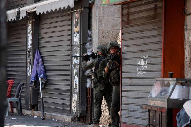 Israeli soldiers take aim during a raid in the old town of Nablus city in the occupied West Bank on June 10, 2025. Israel has occupied the West Bank since 1967, and violence there has soared since the start of the Gaza war in 2023. The West Bank is home to about three million Palestinians, but also some 500,000 Israelis living in settlements that are illegal under international law. - JAAFAR ASHTIYEH / AFP
