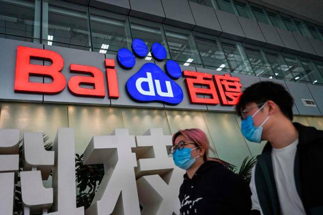 People walk past a Baidu logo outside the company headquarters in Beijing on Feb 2, 2024. AFPpix