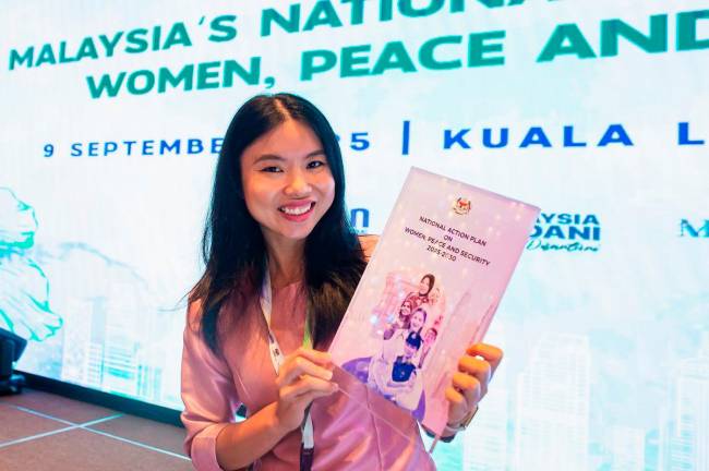 Founder of Stop Online Harm, Saijai Liangpunsakul shows the National Action Plan on Women, Peace and Security after the launch of the plan here today. - Bernama
