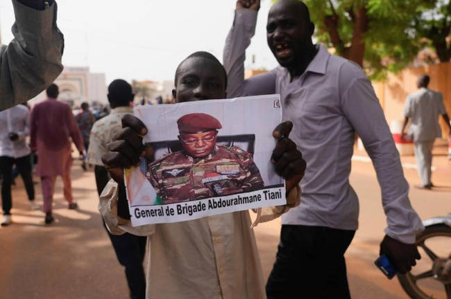 Nigeriens participate in a march called by supporters of coup leader Gen. Abdourahmane Tchiani, pictured, in Niamey, Niger, July 30, 2023. - AP Photo