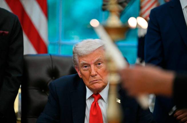 US President Donald Trump looks on as candles are lit during a Diwali celebration with American Indian leaders in the Oval Office of the White House in Washington, DC, on October 21, 2025. - AFP