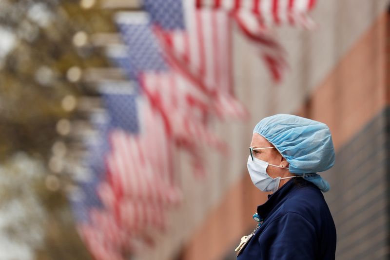 A nurse wearing personal protective equipment watches an ambulance driving away outside of Elmhurst Hospital during the ongoing outbreak of the coronavirus disease (COVID-19) in the Queens borough of New York, U.S., April 20, 2020. -Reuters