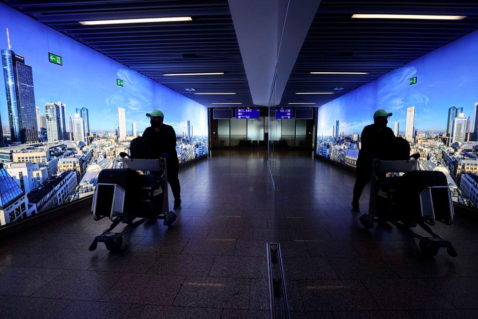 A man pushing a cart is reflected o a mirror as he walks through the corridor at the Frankfurt airport, amid the outbreak of the coronavirus disease (COVID-19), in Frankfurt, Germany, March 29, 2021. REUTERSPIX