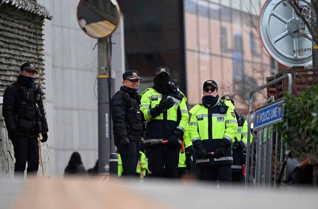 Police officers stand guard as protesters hold a demonstration calling for the ouster of South Korea President Yoon Suk Yeol near the presidential residence in Seoul on December 17, 2024. - Jung Yeon-je / AFP