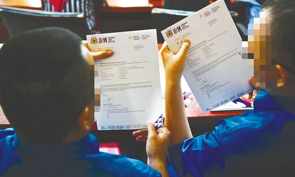 The two inmates, Jep, 36, and Ken, 34, showing off their offer letters to continue their postgraduate studies at Universiti Sains Malaysia (USM).