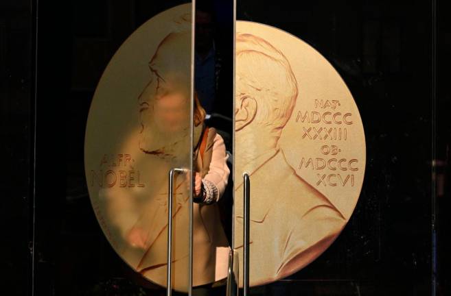 A person opens the door to leave the Swedish Academy ahead of the 2025 Nobel Prize in Literature at the Swedish Academy in Stockholm, Sweden, on October 9, 2025. - AFP