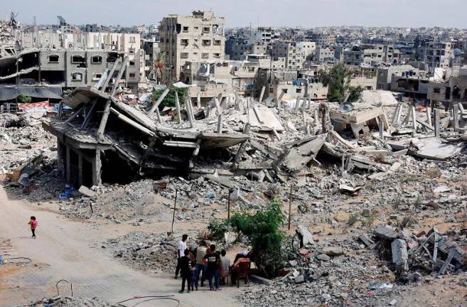 Palestinians sit next to the rubble of houses destroyed in Israel’s military offensive, amid the ongoing conflict between Israel and Hamas, in Khan Younis in the southern Gaza Strip October 7, 2024. - REUTERS/Mohammed Salem/File Photo