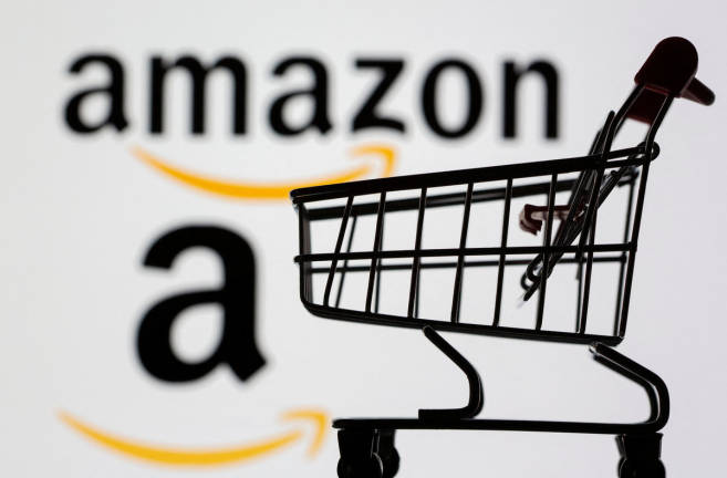 Small toy shopping cart is seen in front of displayed Amazon logo in this illustration taken, July 30, 2021. 0 REUTERS