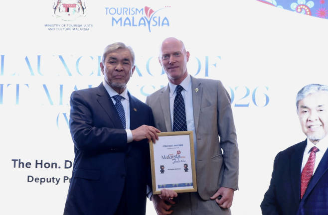 Deputy Prime Minister Datuk Seri Dr Ahmad Zahid Hamidi (left) presents the Strategic Partner Certificate to MAS General Manager (Commercial), Tim Lorimer (right), at the Launch Ceremony of Visit Malaysia Year 2026 (VMY2026) in the United Kingdom, on Tuesday. - BERNAMApix