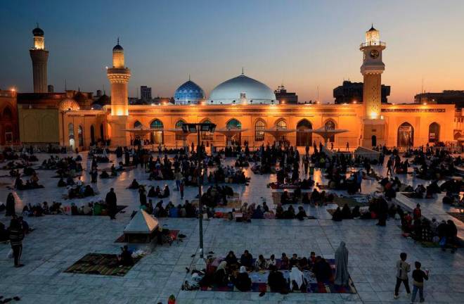 Iraqi Muslims eat Iftar, the meal to end their fast at sunset, during the holy fasting month of Ramadan at the shrine of Sheikh Abdul Qadir al-Gailani in Baghdad, Iraq, March 13, 2025. REUTERSpix