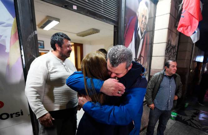Supporters of late Uruguay's President Jose Mujica comfort each other at the Frente Amplio party headquarters in Montevideo on May 13, 2025. Uruguay's former president (2010-2015) Jose Mujica, a former guerrilla fighter and icon of the left in Latin America, died at the age of 89 on May 13, 2025, the government announced. The farmer dubbed the world's poorest president during his presidency for his modest lifestyle had been diagnosed with cancer of the esophagus in May 2024. - DANTE FERNANDEZ / AFP
