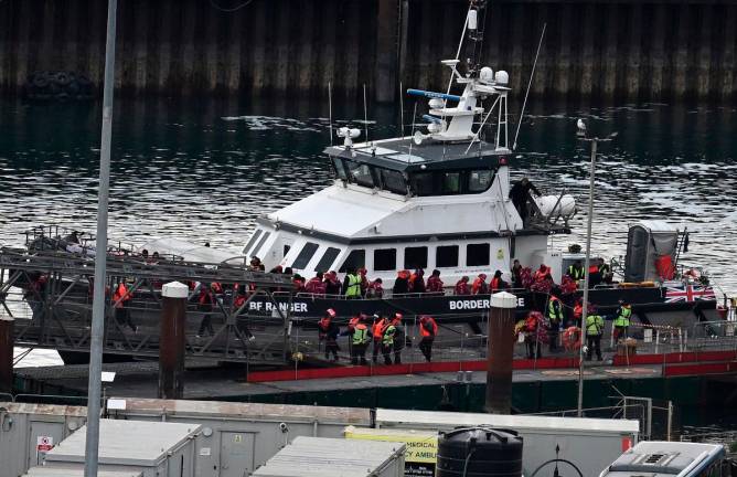 Migrants picked up at sea attempting to cross the English Channel from France, disembark from Border Force vessel 'Ranger' after it arrived at the Marina in Dover, south-east England, on May 21, 2025. - Ben STANSALL / AFP