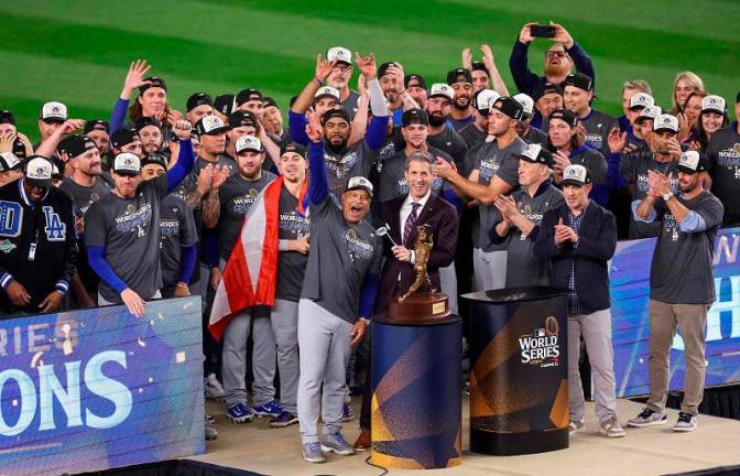 Manager Dave Roberts #30 and the Los Angeles Dodgers celebrate on the trophy stand after defeating the New York Yankees 7-6 in game 5 to win the 2024 World Series at Yankee Stadium on October 30, 2024 in the Bronx borough of New York City. Luke Hales/Getty Images/AFP