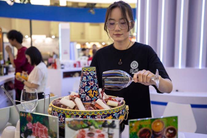A staff member prepares a serving of tender mutton cooked in red wine-added broth during the Fifth China (Ningxia) International Wine Culture and Tourism Expo in Yinchuan, northwest China’s Ningxia Hui Autonomous Region, on June 11, 2025. (Xinhua/Yang Zhisen)
