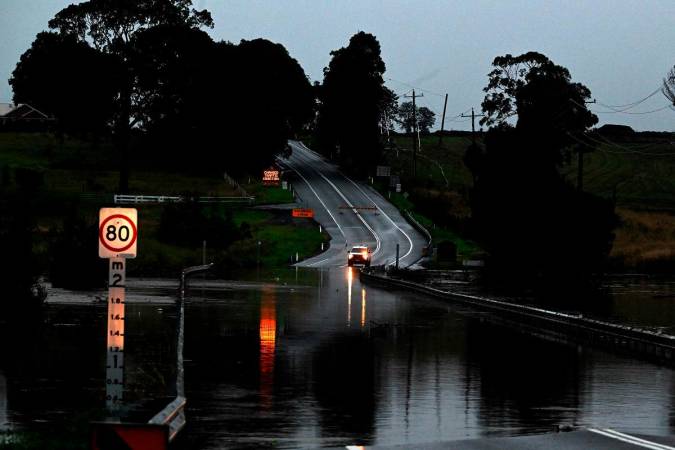 A road is seen flooded from the over flowing Wallis Creek in Gillieston Heights near New South Wales town of Maitland on May 22, 2025. Record floods cut a destructive path through eastern Australia on May 23, caking houses in silt, washing out roads and separating 50,000 people from help. - Saeed KHAN / AFP