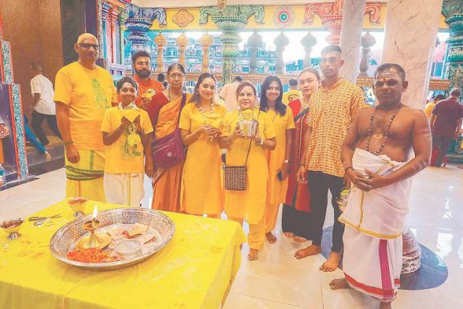 Ramesh Marathamuthan (left) with his family and a priest performing prayers at a temple in Batu Caves to give thanks for the recovery of his daughter Sasmetasri (fourth from right). - ADIB RAWI YAHYA/THESUN