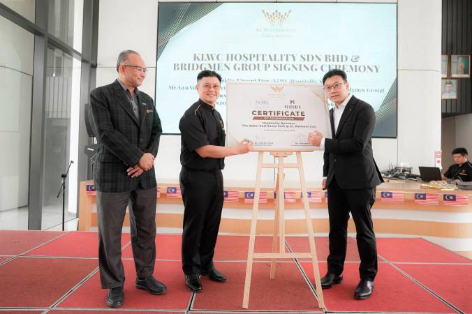 KLWC Hospitality Sdn Bhd executive director Datuk Seri Dr. Vincent Tiew &amp; Bridgmen Group rep- Gyn Voong while witnessed by guest of honour Ahmad Husni Ahmad Basri (Deputy Director of Package Development Division,Tourism Malaysia)