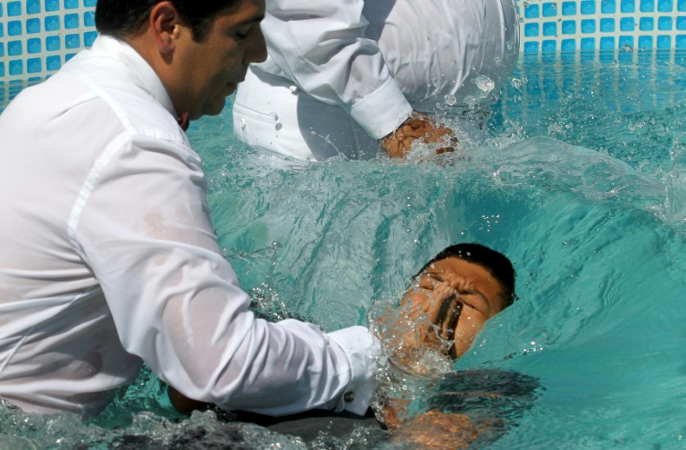 “Do you believe in Jesus Christ?” a minister asked newly baptized members, who responded “Amen!” with their right hands raised before being plunged into the full-body baptismal pools. — AFP