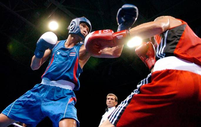 (FILES) Thailand’s Somluck Kamsing (L) competes with Canada’s Benoit Gaudet during their Olympic Games preliminary featherweight (57 kg) boxing match in Athens on August 16, 2004. A Thai court on January 23, 2025 sentenced the country’s first Olympic gold medallist to just over three years in prison for the abduction and attempted rape of a teenager. - Joe KLAMAR / AFP)