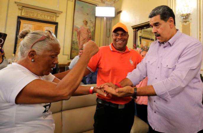 Venezuela’s President Nicolas Maduro (R) talking to relatives of 238 Venezuelan deportees to a maximum-security prison in El Salvador, at Miraflores Presidential Palace in Caracas AFPpix