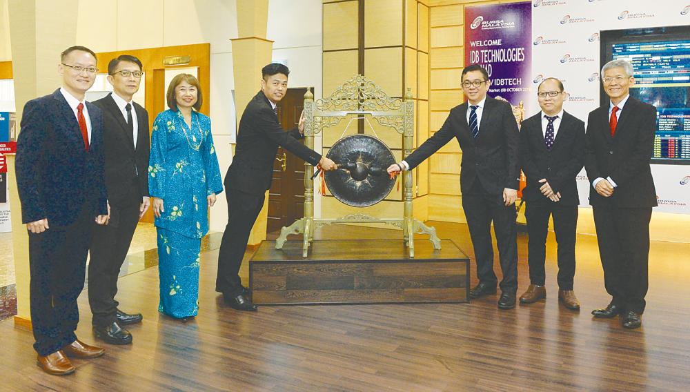 IDB CEO Cheah Kah Beng (left) and chief technology officer Lim Kuei Boon hitting the gong at the listing ceremony yesterday.
