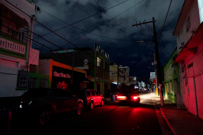 A car drives through a dark street as Puerto Ricans were without electricity early on New Year’s Eve after a grid failure left nearly all of the island without power, in San Juan - REUTERSpix