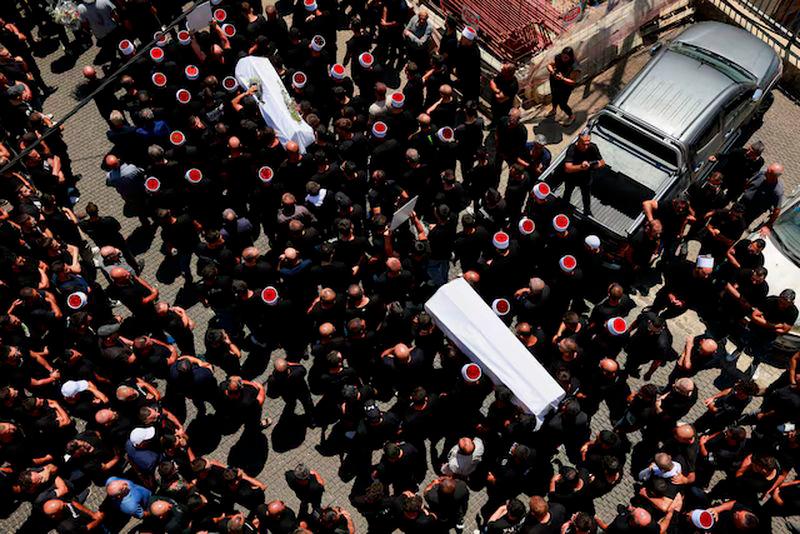 Mourners carry coffins, during the funeral of children who were killed at a soccer pitch by a rocket Israel says was fired from Lebanon, in Majdal Shams, a Druze village in the Israeli-occupied Golan Heights - REUTERSpix