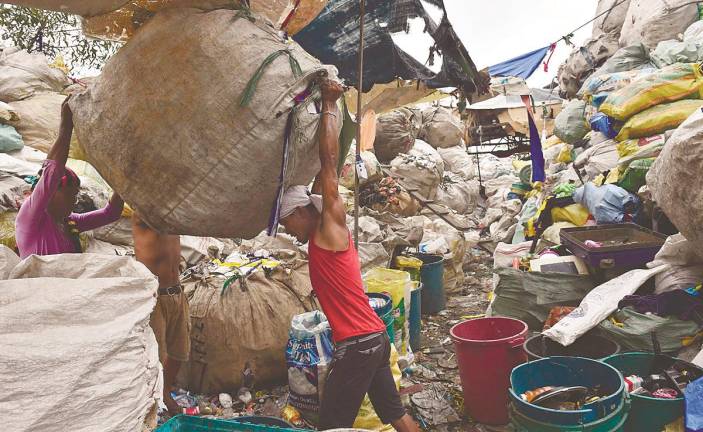 In many cities, informal waste pickers perform the essential work of recovering recyclables. – AFPpix
