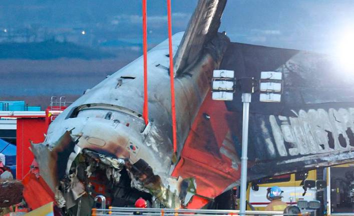 Firefighters and rescue personnel work near the scene where a Jeju Air Boeing 737-800 series aircraft crashed and burst into flames at Muan International Airport in South Jeolla Province, some 288 kilometres southwest of Seoul on December 29, 2024. A Jeju Air plane carrying 181 people from Thailand to South Korea crashed on arrival, smashing into a barrier and bursting into flames, leaving all but two feared dead. - - South Korea OUT / NO ARCHIVES - RESTRICTED TO SUBSCRIPTION USE. - YONHAP / AFP