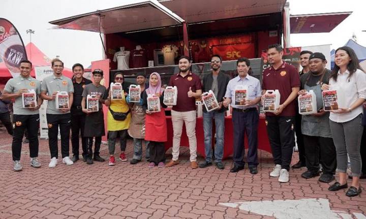 Tengku Amir Shah, the Crown Prince of Selangor, as well as Club President of Selangor Football Club (eighth from the left) and Vinesh Sinha, CEO of FatHopes Energy (ninth from the left), visiting one of the Used Cooking Oil (UCO) collection booths.