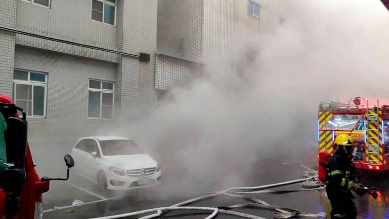 Firefighters respond to a fire at Donggang Antai Hospital in Pingtung County on October 3, 2024. Nine people died on October 3 after a fire ripped through a hospital in southern Taiwan, the island's fire agency said. - CNA / AFP) / Hong Kong OUT