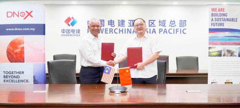 Faizal (left) exchanging signed documents with Sinohydro Malaysia managing director Zhou Jiayi (right).