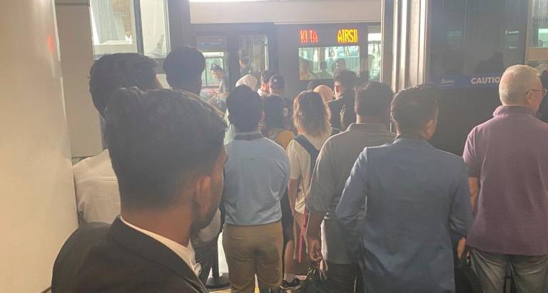 Frustrated passengers walking toward airport exits after the aerotrain failed to transport them between Terminal 1’s Main Terminal and Satellite Building. - Pic credit X @afiqmukhtar