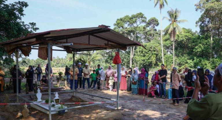 Some individuals allegedly taking soil from the grave of Nurly Shahirah Azman in the belief that it brings blessings. - BERNAMA