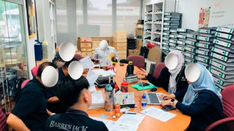 MACC officers enquiring suspects during yesterday’s raid. - Pic courtesy of MACC