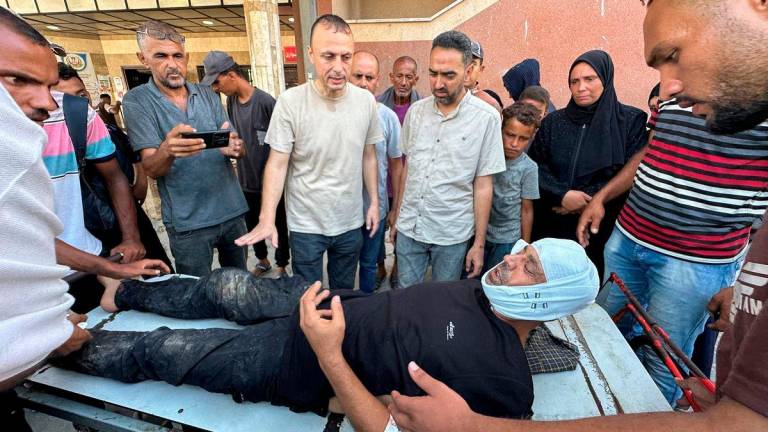 Photographer Hatem Khaled, a Reuters contractor, is assisted after being wounded in Israeli strikes on Nasser Hospital that killed journalists, including Reuters contractor and cameraman Hussam al-Masri. Reuterspix/TPX Images