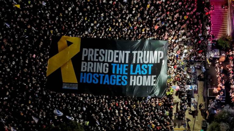 A drone view shows participants holding a large banner during a rally held by hostage families and supporters at “Hostages Square” to demand the immediate release of the bodies of the deceased hostages who were kidnapped in the deadly October 7, 2023, attack on Israel by Hamas, in Tel Aviv, Israel, October 18, 2025. REUTERS/Ilan Rosenberg