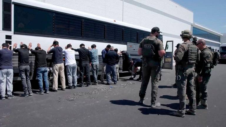 Detainees are made to stand against a bus before being handcuffed, during a raid by federal agents where about 300 South Koreans were among 475 people arrested at the site of a $4.3 billion project by Hyundai Motor and LG Energy Solution to build batteries for electric cars in Ellabell, Georgia, U.S., September 4, 2025 in a still image taken from a video. - U.S. Immigration and Customs Enforcement/Handout via REUTERSPIX