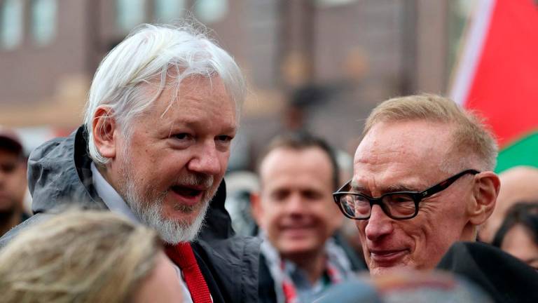WkikLeaks founder Julian Assange (L) and former Australian minister for foreign affairs Bob Carr (R) chat during a pro-Palestinian rally against Israel’s actions and the ongoing food shortages in the Gaza Strip, in Sydney on August 3, 2025. - DAVID GRAY / AFP