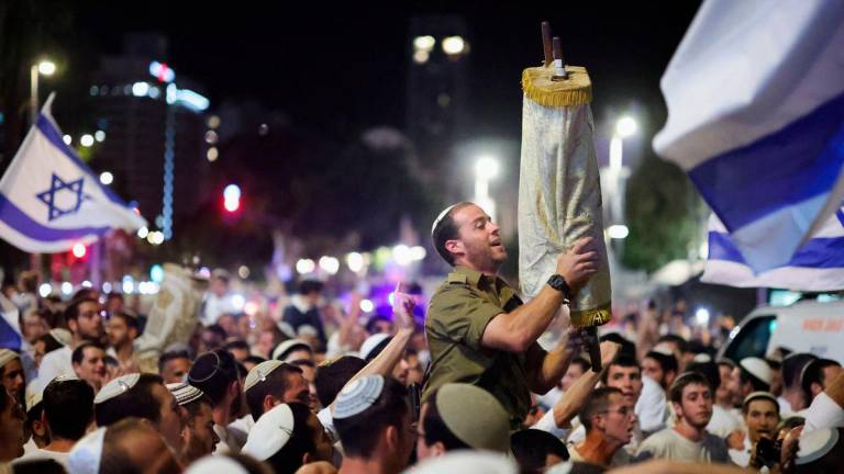 A man holds a Torah after Simchat Torah, which marks the final reading of the Torah, on the day the bodies of deceased hostages kidnapped during the deadly October 7, 2023 attack by Hamas are brought to Israel, at Hostages Square. Reuterspix