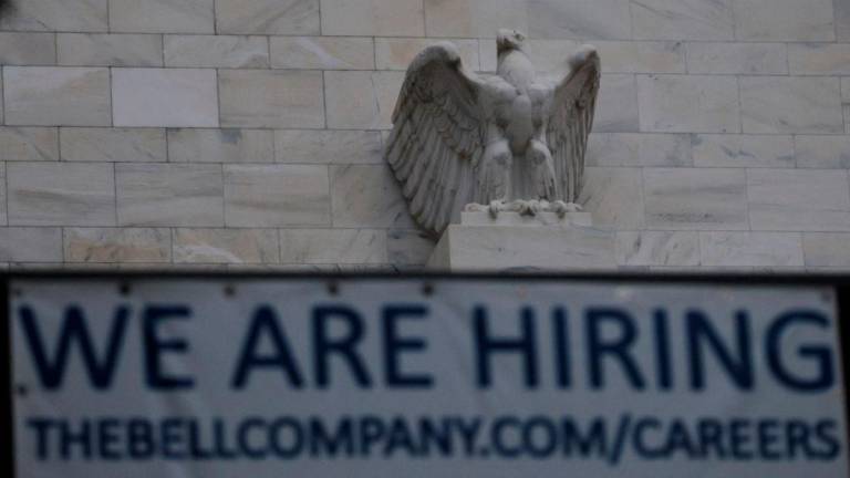 An eagle tops the U.S. Federal Reserve building's facade above a We Are Hiring notice from construction company renovating the building, as U.S. President Donald Trump said he was firing Federal Reserve Governor Lisa Cook over alleged improprieties in obtaining mortgage loans, in Washington, D.C., U.S., August 26, 2025. - REUTERSPIX