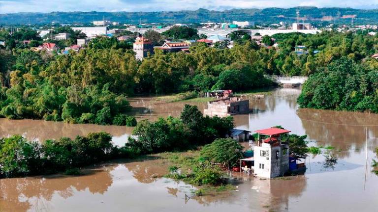 This aerial photo shows a flooded area due to the heavy rains brought about by Tropical Storm Trami in Tuguegarao City, province of Cagayan on October 25, 2024. Philippine rescue workers battled floodwaters on October 25 to reach residents still trapped on the roofs of their homes as Tropical Storm Trami moved out to sea after killing at least 40 people. - John Dimain / AFPpix