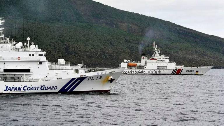 A China Coast Guard vessel No.2502 sails near a Japan Coast Guard vessel Motobu off Uotsuri Island, one of a group of disputed islands called Senkaku Islands in Japan, also known in China as Diaoyu Islands, in the East China Sea - REUTERSpix