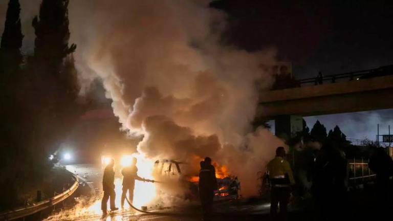 Firefighters extinguish a burning UNIFIL vehicle on the road leading to Beirut’s international airport on Friday night © IBRAHIM AMRO / AFP