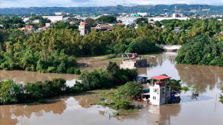 This aerial photo shows a flooded area due to the heavy rains brought about by Tropical Storm Trami in Tuguegarao City, province of Cagayan on October 25, 2024. Philippine rescue workers battled floodwaters on October 25 to reach residents still trapped on the roofs of their homes as Tropical Storm Trami moved out to sea after killing at least 40 people. - John Dimain / AFP