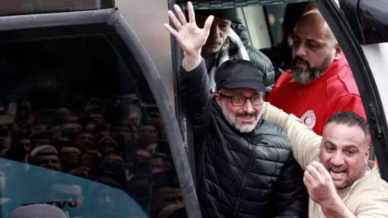 A former Palestinian prisoner released by Israel waves to a cheering crowd as he steps out of a bus in the occupied West Bank city of Ramallah on February 8, 2025. © Jaafar Ashtiyeh, AFP