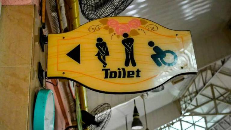 A sign shows directions to a public toilet at a food court in Singapore © Roslan RAHMAN / AFP